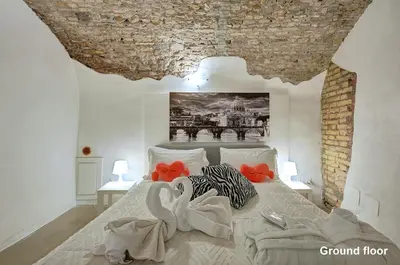 a bedroom with a large bed with red flowers on it at Casa a Monti in Rome