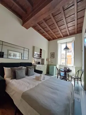a bedroom with a large bed and a dining room at Boutique Signature Suite in the Heart of Ancient Rome in Rome