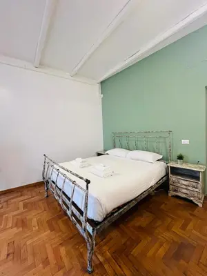 a bed in a room with a green wall at La Civetta a Navona in Rome