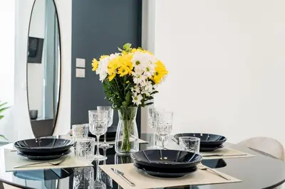 a table with a vase of yellow and white flowers at Domina Apartments Roma - San Pietro 1 in Rome