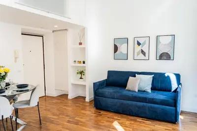 a blue couch in a living room with a table at Domina Apartments Roma - San Pietro 1 in Rome