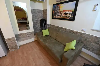 a living room with a brown couch with two yellow pillows at Holiday City Center in Rome
