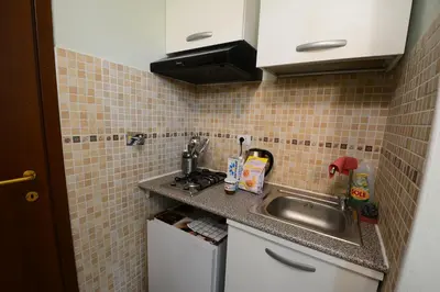 a small kitchen with a sink and a tiled wall at Holiday City Center in Rome