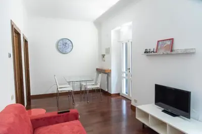 a living room with a red couch and a table at Welcome to the ColosseHome in Rome