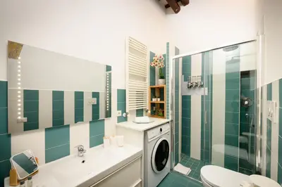 a bathroom with green and white tile and a washing machine at Mommy's - Vatican House in Rome