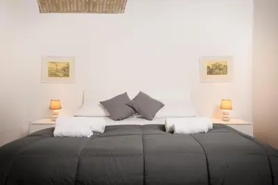 a bedroom with a large bed with two lamps at Mommy's - Vatican House in Rome