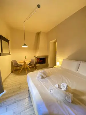 a bedroom with a bed with a fireplace and a table at Tiziano's house San Pietro Station in Rome