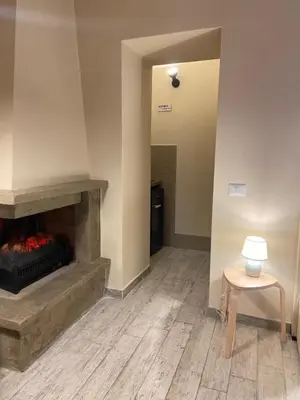 a living room with a fireplace and a stool at Tiziano's house San Pietro Station in Rome