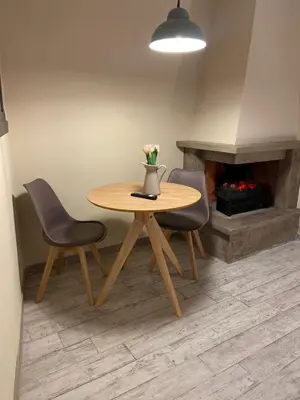 a table with two chairs and a vase with flowers on it at Tiziano's house San Pietro Station in Rome