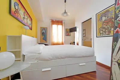 a bedroom with a white bed and a desk at YCH-Una finestra sulla Cupola di San Pietro in Rome