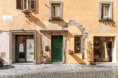 a building with a green door on a street at Campo de' Fiori Enchanting Attic in Rome