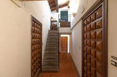 a hallway with wooden doors and stairs in a house at Campo de' Fiori Enchanting Attic in Rome