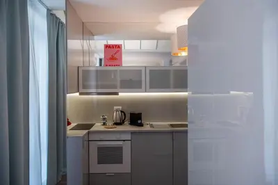 a kitchen with white cabinets and a counter top at COLOSSEUM VIEW ACCOMODATION in Rome
