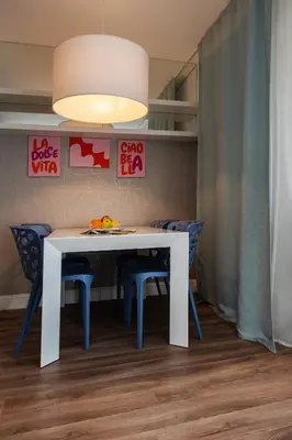 a dining room with a white table and blue chairs at COLOSSEUM VIEW ACCOMODATION in Rome