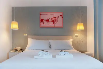 a bedroom with a white bed with two towels on it at COLOSSEUM VIEW ACCOMODATION in Rome