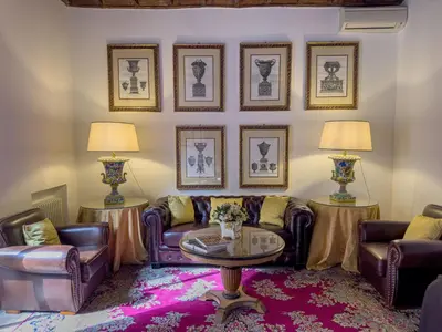 a living room with couches and tables and pictures on the wall at Via Giulia Charming Apartment with Balcony in Rome