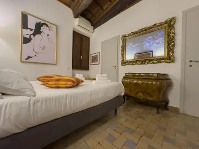 a bedroom with a bed and a tv on the wall at Via Giulia Charming Apartment with Balcony in Rome