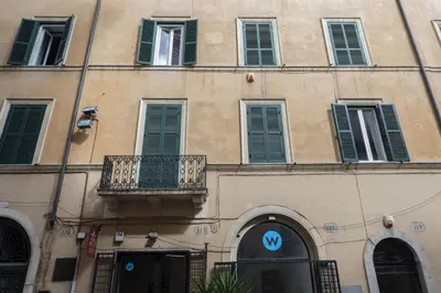 a building with a sign on the side of it at Via Giulia Charming Apartment with Balcony in Rome