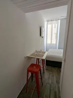 a small room with a bed and a red stool at Borgo Place in Rome