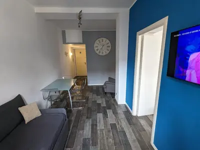 a living room with a couch and a table and a clock at Borgo Place in Rome