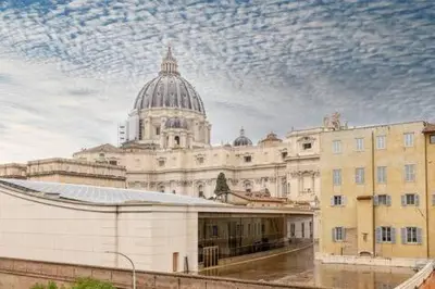 a large white building with a domed building at Camera singola con vista su San Pietro in Rome
