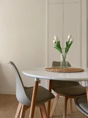 a white table with two chairs and a vase of flowers at ALMA - Vatican Apartment in Rome