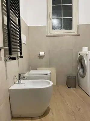 a bathroom with a toilet and a washing machine at ALMA - Vatican Apartment in Rome