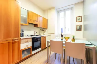 a kitchen with wooden cabinets and a table with chairs at Gioia Romana in Rome