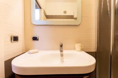 a white sink in a bathroom with a mirror at Gioia Romana in Rome