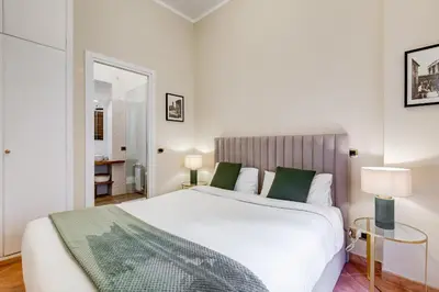 a bedroom with a large white bed with green pillows at URBANA 18 in Rome