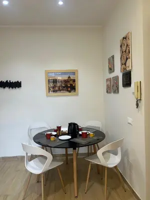 a dining room table with white chairs in a room at Casa Riboty by GHOR in Rome