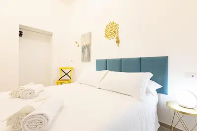 a bedroom with a white bed with a blue headboard at Trastevere Exclusive Three Bedroom Apartment in Rome