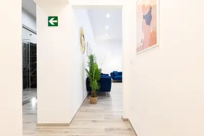 a hallway with white walls and a potted plant at Trastevere Exclusive Three Bedroom Apartment in Rome