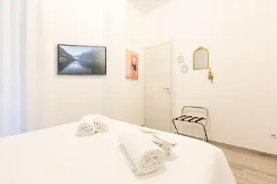 a white bedroom with a bed with towels on it at Trastevere Exclusive Three Bedroom Apartment in Rome