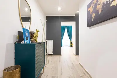 a living room with a blue cabinet and a mirror at Trastevere Exclusive Three Bedroom Apartment in Rome
