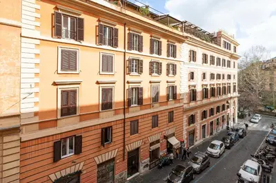 a tall building with cars parked on a street at Trastevere Exclusive Three Bedroom Apartment in Rome