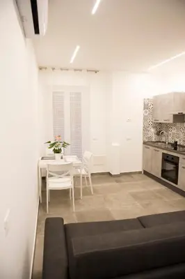 a living room with a table and a kitchen at A Casa di Lù a Roma Casa Vacanze in Rome