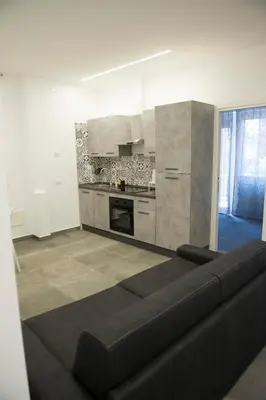 a living room with a black couch in a kitchen at A Casa di Lù a Roma Casa Vacanze in Rome