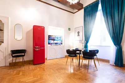 a room with a red refrigerator and a table with chairs at Spanish Steps Exclusive Apartment in Rome