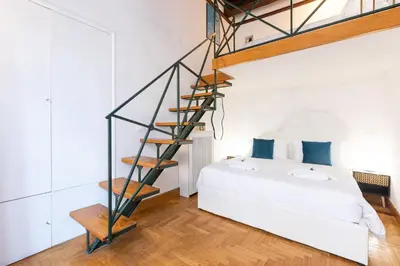 a bedroom with a white bed and a spiral staircase at Spanish Steps Exclusive Apartment in Rome