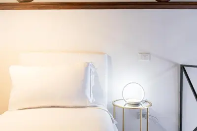a bedroom with a white bed and a mirror at Spanish Steps Exclusive Apartment in Rome