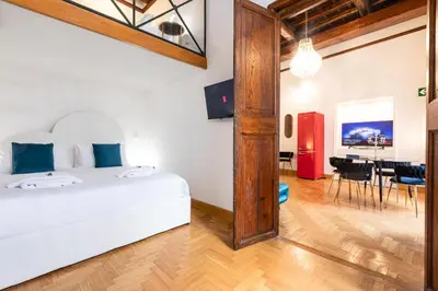 a bedroom with a white bed and a dining room at Spanish Steps Exclusive Apartment in Rome