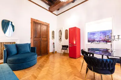 a living room with a table and a red refrigerator at Spanish Steps Exclusive Apartment in Rome