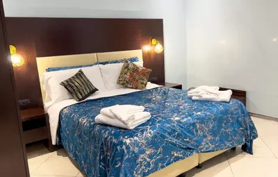 a bedroom with two beds and a tv on the wall at Sofia Guest House in Rome