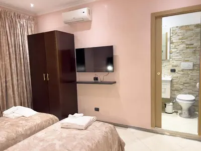 a kitchen with a table and chairs and a refrigerator at Sofia Guest House in Rome