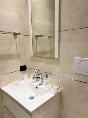 a bedroom with a bed and a bathroom with a sink at Sofia Guest House in Rome