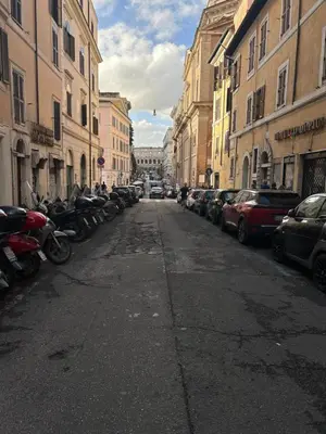 a city street with parked cars and buildings at Serpenti 147 - Colosseum Apt in Rome