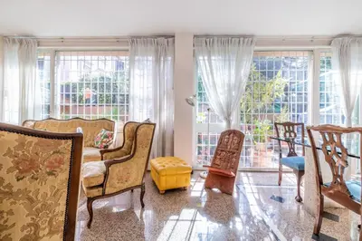 a living room filled with furniture and large windows at Maximo Luxe -Villa & Apartment in Rome