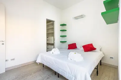two beds in a white room with red pillows at Maximo Luxe -Villa & Apartment in Rome