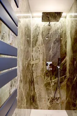a bathroom with a shower with a stone wall at Domus Maxima - Rome Suite & Rooms in Rome